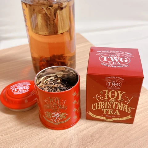Joy Christmas Teaと書いてある赤い小さな紅茶缶とそれが入っていた赤い箱。
箱には缶と同じようにJoy Christmas Teaと書いてある。
その２つの後ろにガラスタンブラーに入ったお茶。
